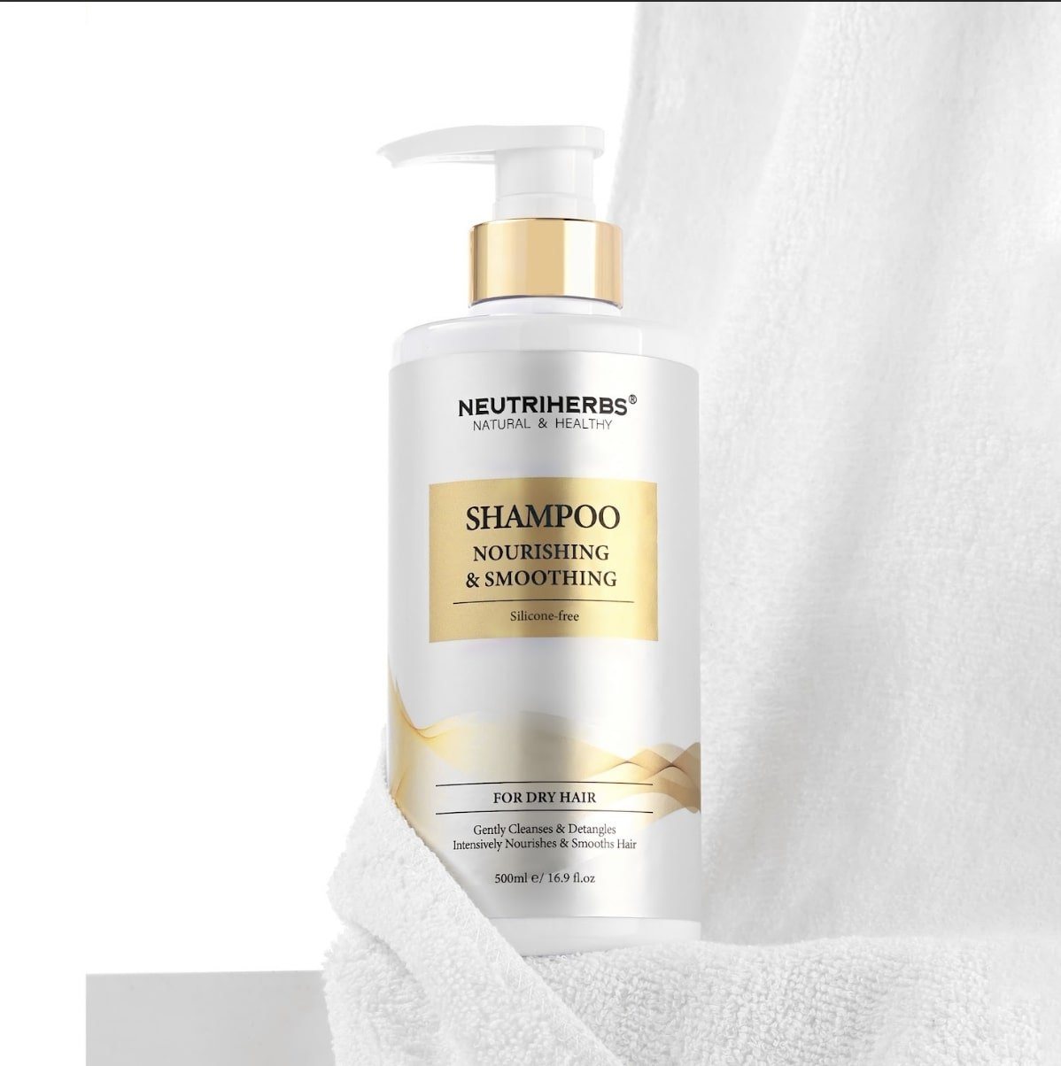 Maitinamasis šampūnas sausiems plaukams šalia balto rankšluosčio