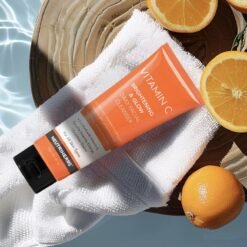 Veido prausiklio su vitaminu C tūbelė šalia apelsino – odai gaivinti